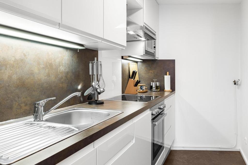 慕尼黑PRIME - City Apartment für 6 - Neu & Modern的厨房配有白色橱柜和水槽