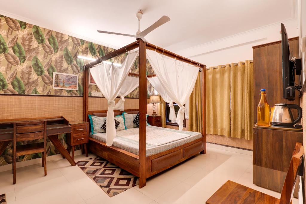 诺伊达House of Comfort Noida的一间卧室配有一张天蓬床和一张书桌