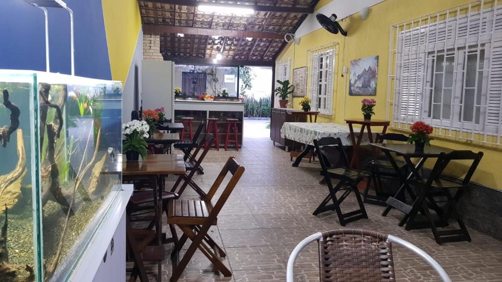 阿拉亚尔-杜卡布Hostel Caminho da Praia的一间带桌椅的餐厅和一个鱼缸