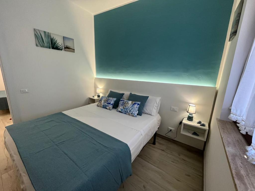 圣维托罗卡波Ca San Vito Lo Capo Villa Maria的一间小卧室,配有一张床和蓝色的墙壁