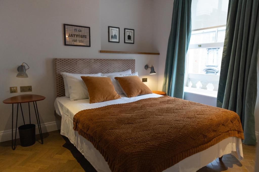 伦敦THE KNIGHT OF NOTTINGHILL的一间卧室设有一张大床和一个窗户。
