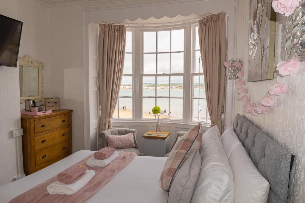 韦茅斯Seacrest Guest House的一间卧室设有一张床和一个大窗户