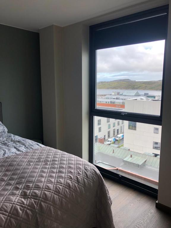 波多Rom m/bad i Bodø sentrum的一间卧室设有一张床和一个大窗户
