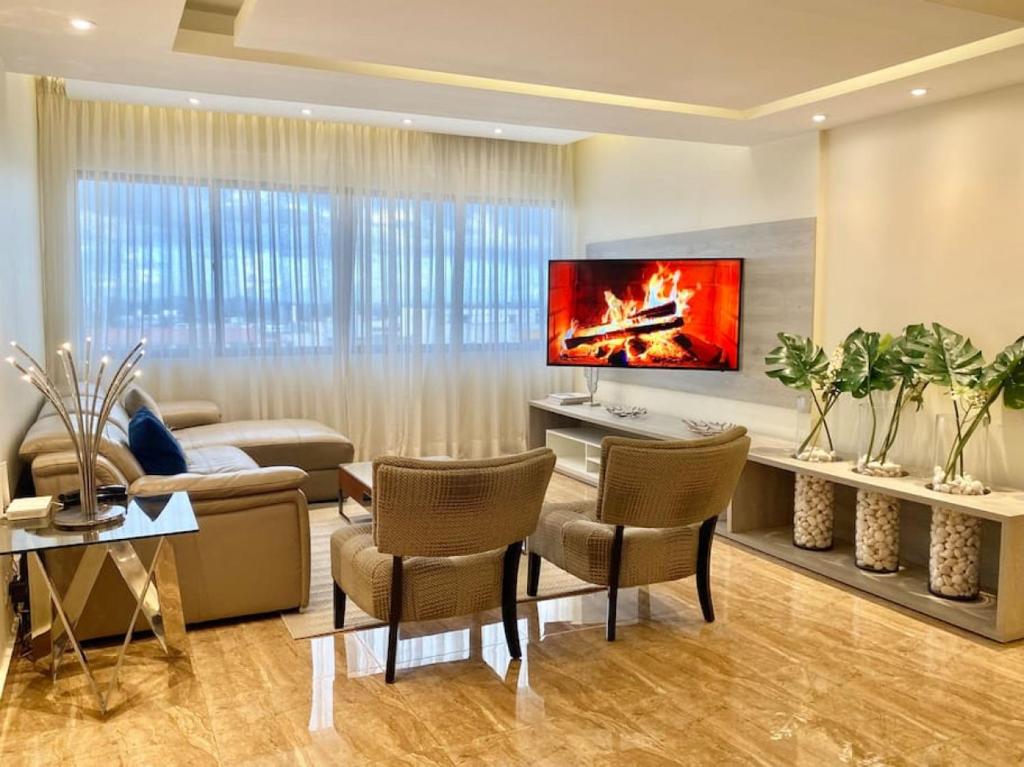 圣多明各Lovely Sto Dgo Center Apt的客厅配有沙发和墙上的电视