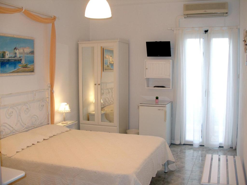 普拉卡米洛斯Arethousa的一间白色卧室,配有床和电视