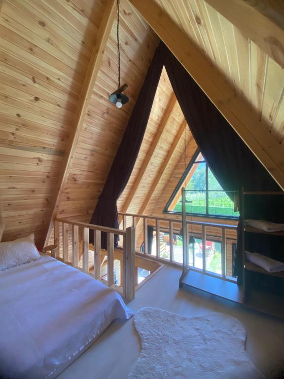 萨潘贾Sıcak havuzlu dağ evi的阁楼卧室设有1张床和1扇大窗户