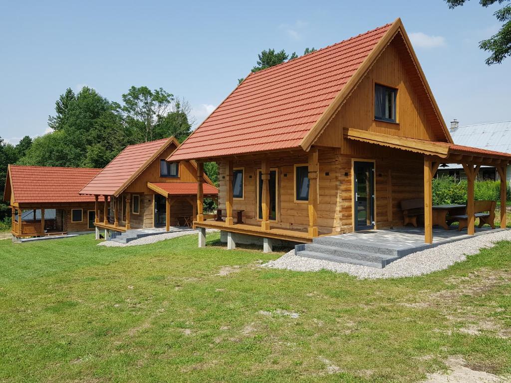 WroceńKraina Biebrzy - domki nad Biebrzą的红屋顶的一排木房子