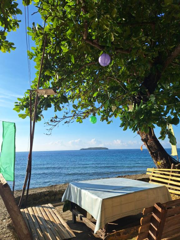 奥斯洛布Island Front - Bangcogon Resort and Restaurant的海滩上的桌子,背靠大海