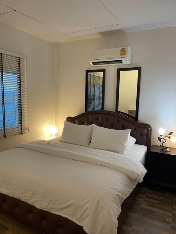 达叻府Rynn Hotel的卧室配有一张带镜子的白色大床