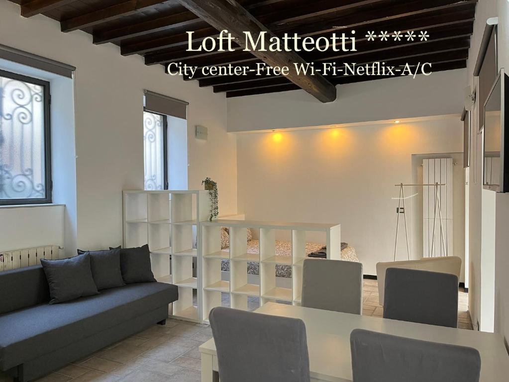 布斯托阿西齐奥Loft Matteotti - Studio in centro的客厅配有沙发、桌子和书架