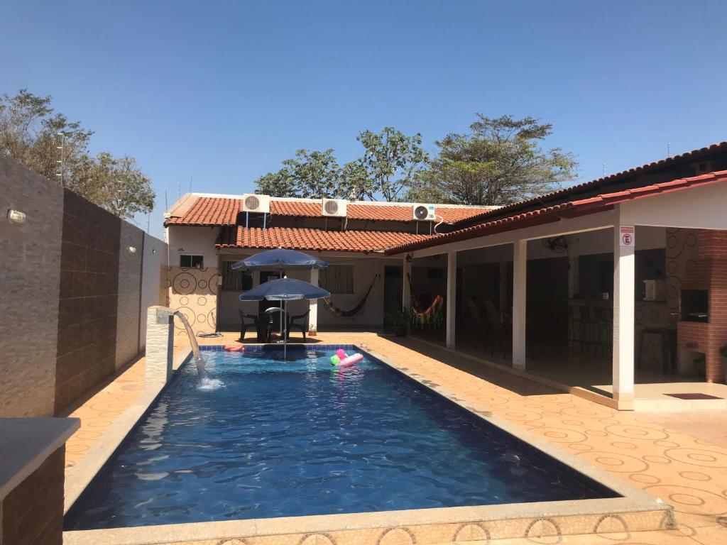 Sao Miguel do AraguaiaRancho peixe grande的房屋前带遮阳伞的游泳池