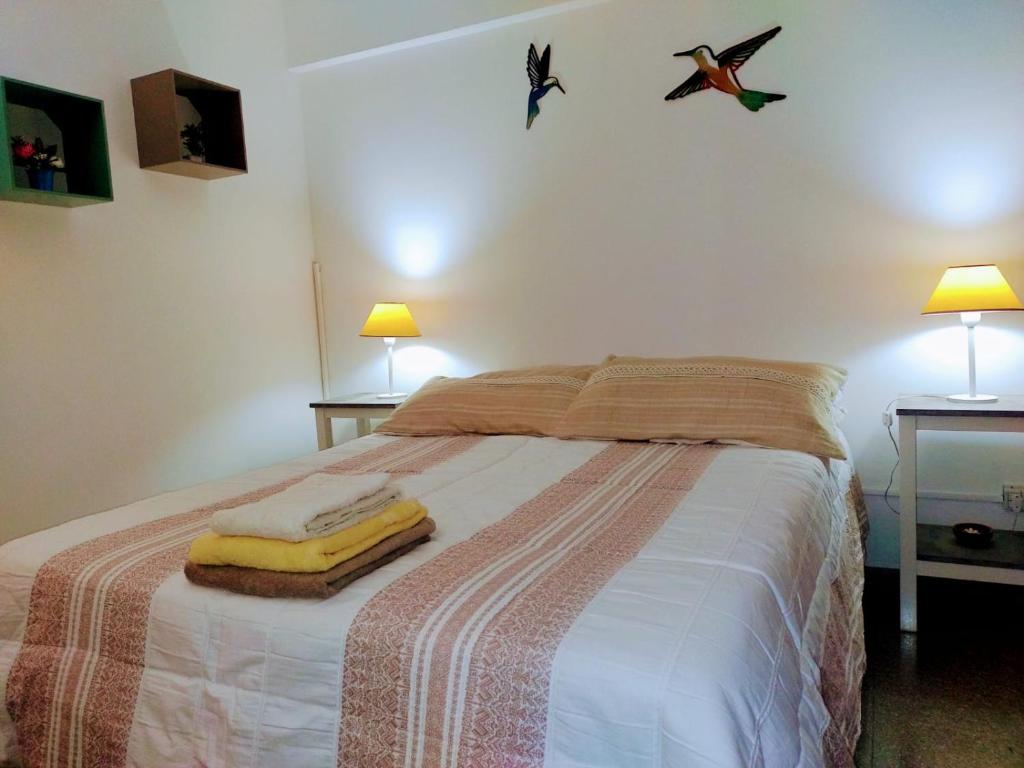 瓜伊马延Departamento Mamá Lucia的一间卧室配有一张带两盏灯和两条毛巾的床。