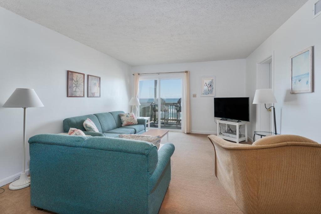 罗丹特7055 - Hatteras High 8C by Resort Realty的客厅配有2张蓝色沙发和1台电视