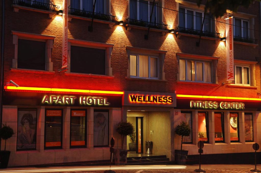 布鲁塞尔健康公寓酒店的楼边有 ⁇ 虹灯标志的酒店