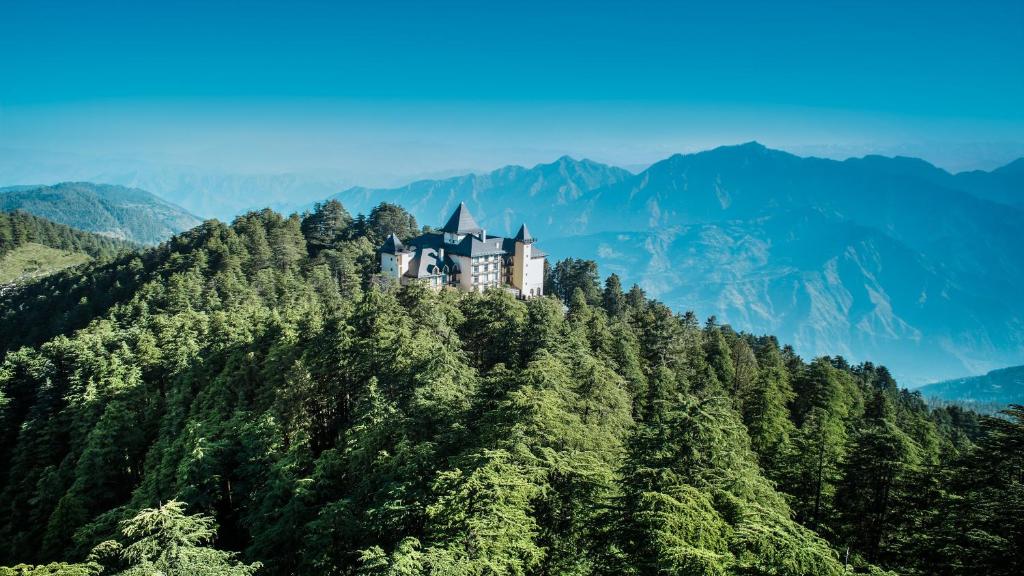 西姆拉Wildflower Hall, An Oberoi Resort, Shimla的树顶上的城堡