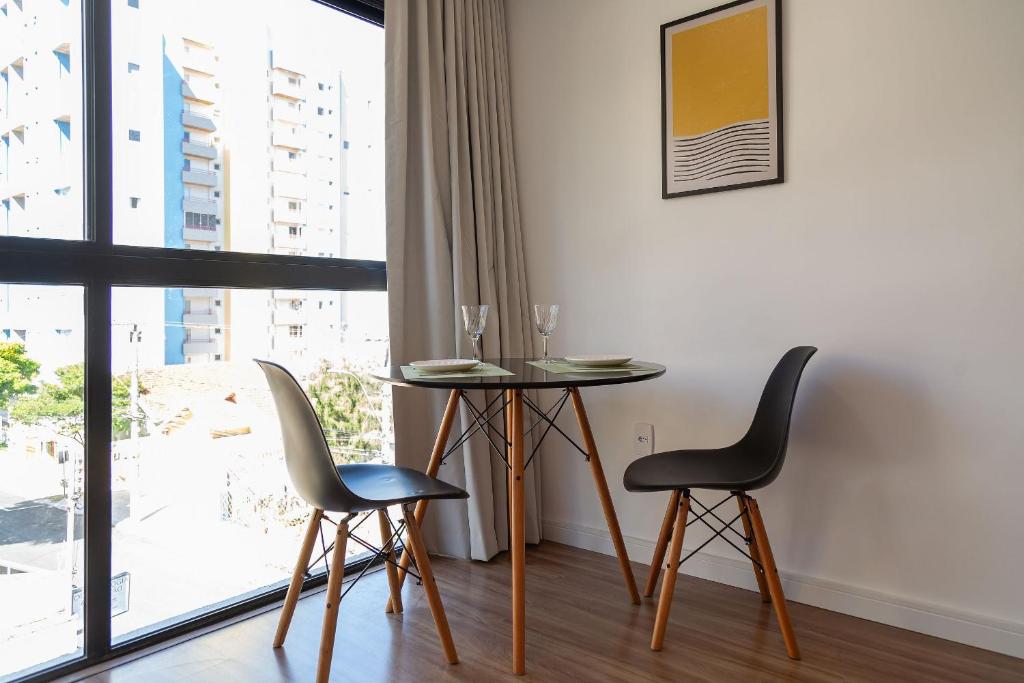 波苏斯-迪卡尔达斯Maravilhoso e elegante studio para casal PGO412的一间带桌椅和窗户的用餐室