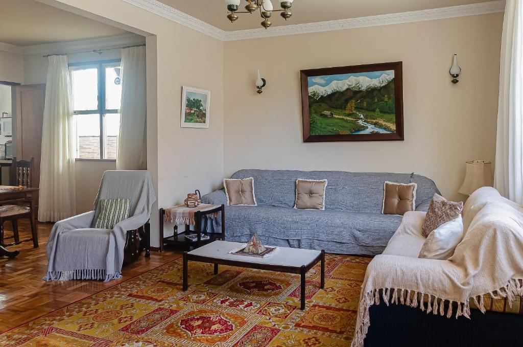 彼得罗波利斯Chamosa e aconchegante casa em Petrópolis VGL041的客厅配有蓝色的沙发和桌子