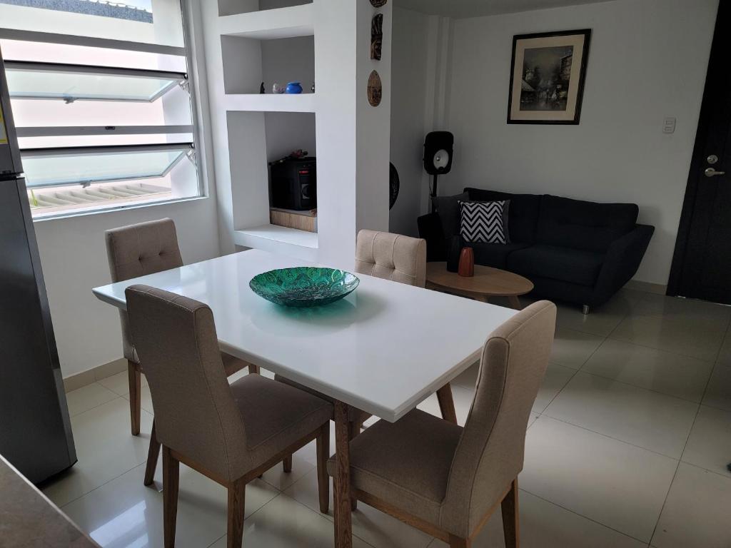 巴兰基亚Espectacular y amplio apartamento amoblado的白色的餐桌,椅子和碗