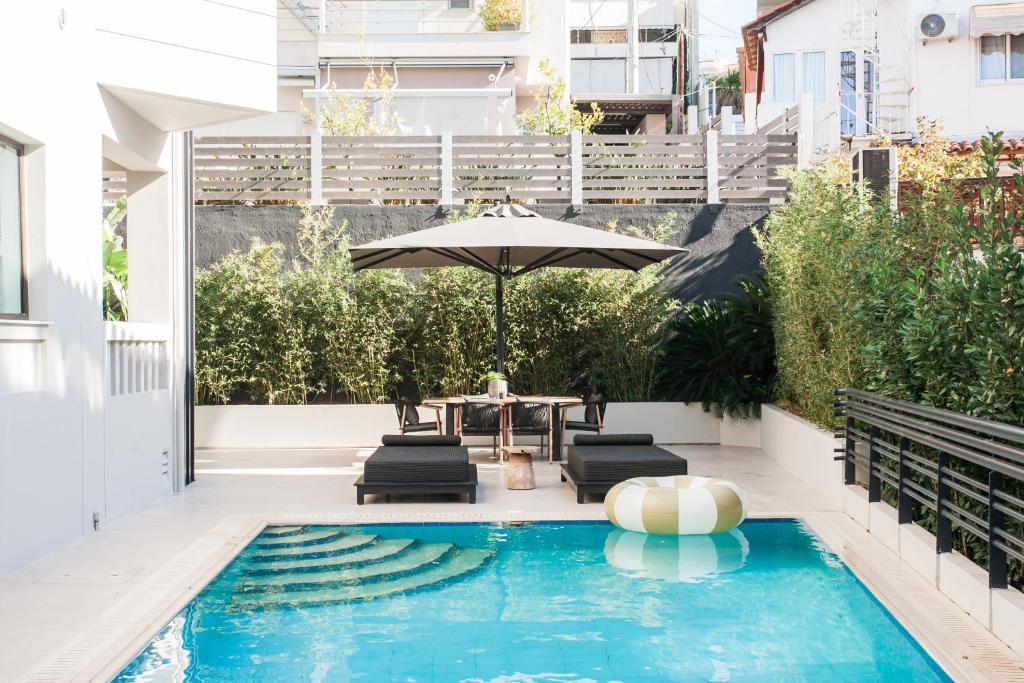 雅典Sol Residence - Private Pool Gym Glyfada的一个带遮阳伞和椅子及桌子的游泳池