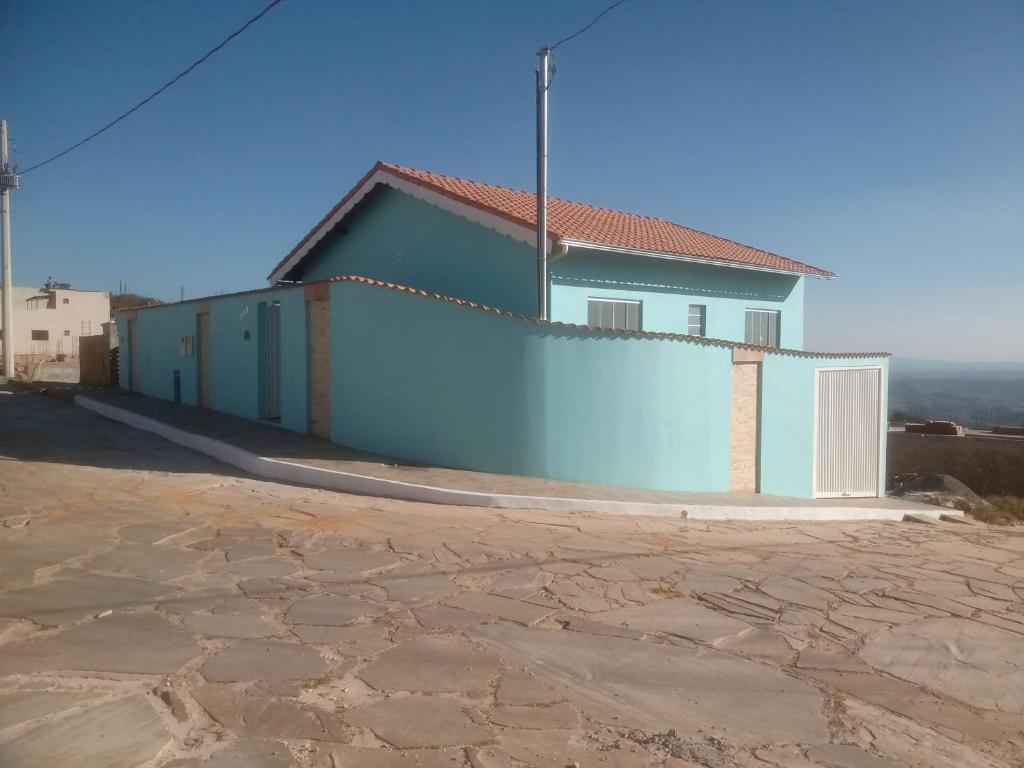 圣托梅-达斯莱特拉斯Casa Beija Flor的前面有白色围栏的蓝色房子