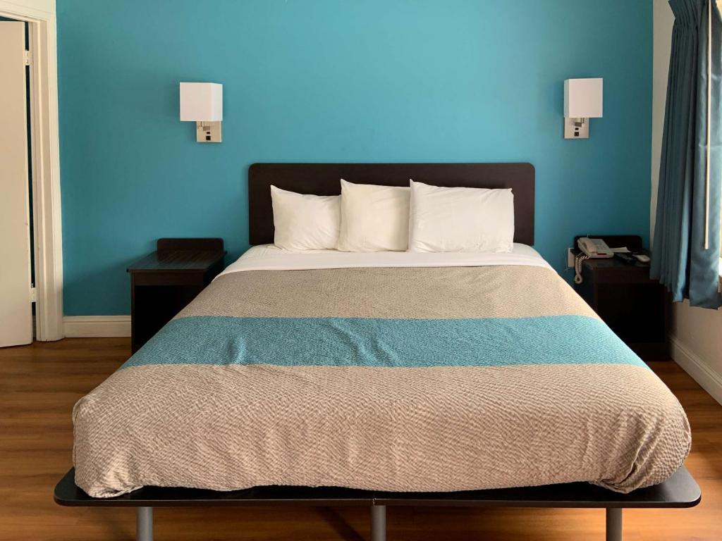 皮斯莫比奇皮斯莫海滩6号汽车旅馆 - 太平洋的一间卧室配有一张蓝色墙壁的床