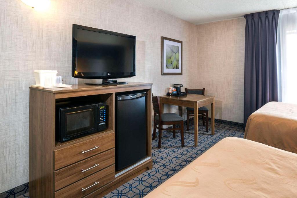 惠特比惠特比品质套房的酒店客房的梳妆台上配有平面电视