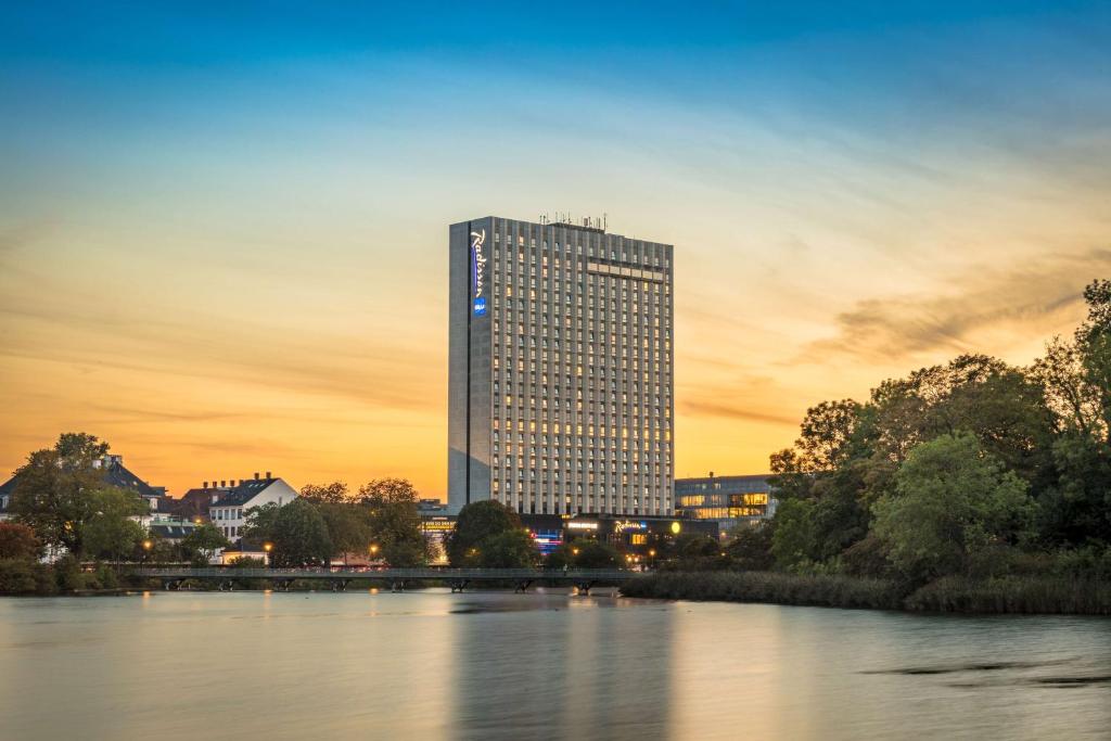 哥本哈根哥本哈根斯堪的纳维亚丽笙酒店的日落时分坐在河边的高楼