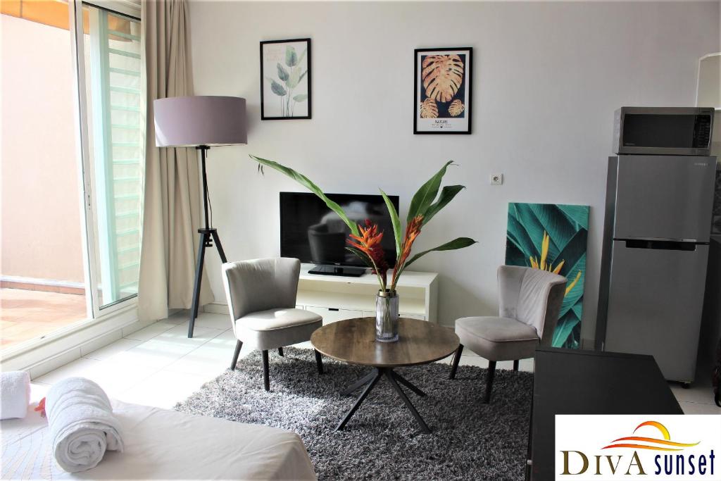 帕皮提Tahiti Diva Sunset studio的客厅配有桌椅和电视。