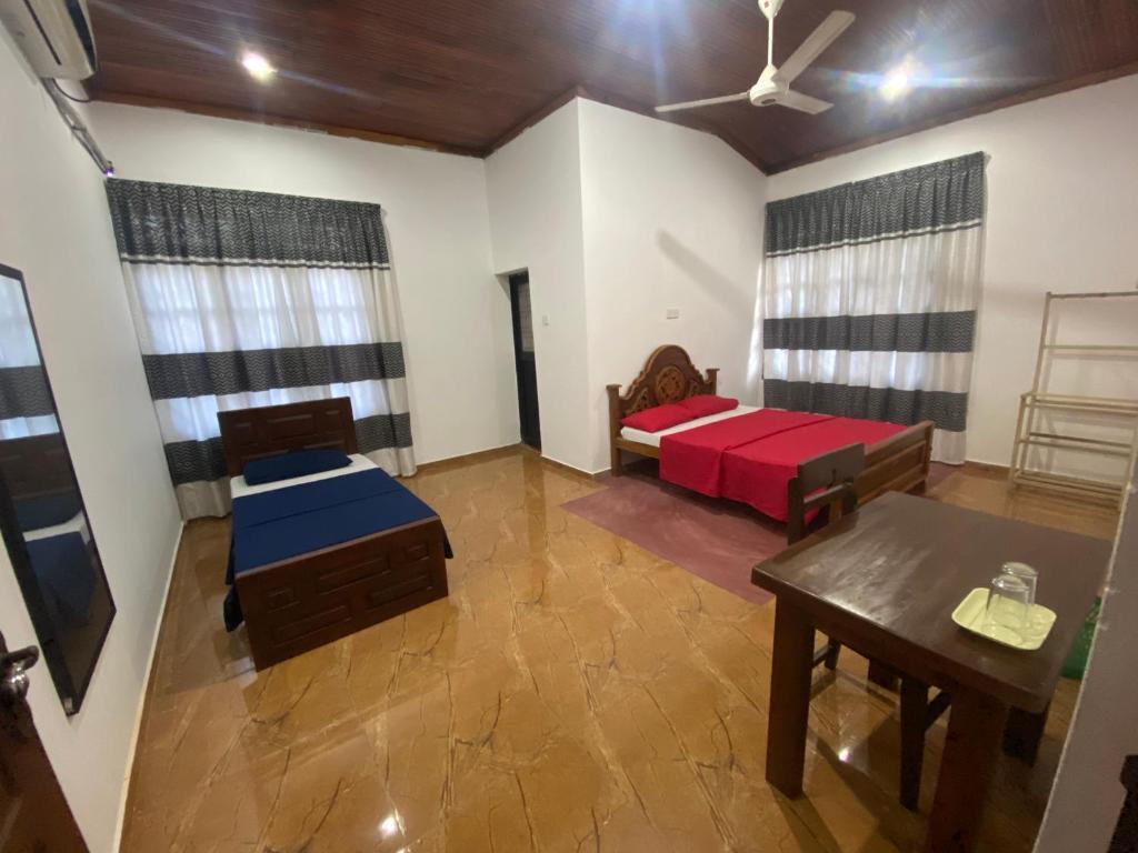 拜蒂克洛East Gate 8-9 Batticaloa的客厅配有床和桌子