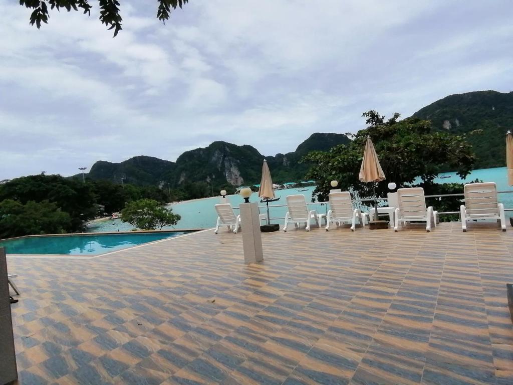 皮皮岛皮皮岛景观酒店的一组椅子和遮阳伞,位于游泳池旁