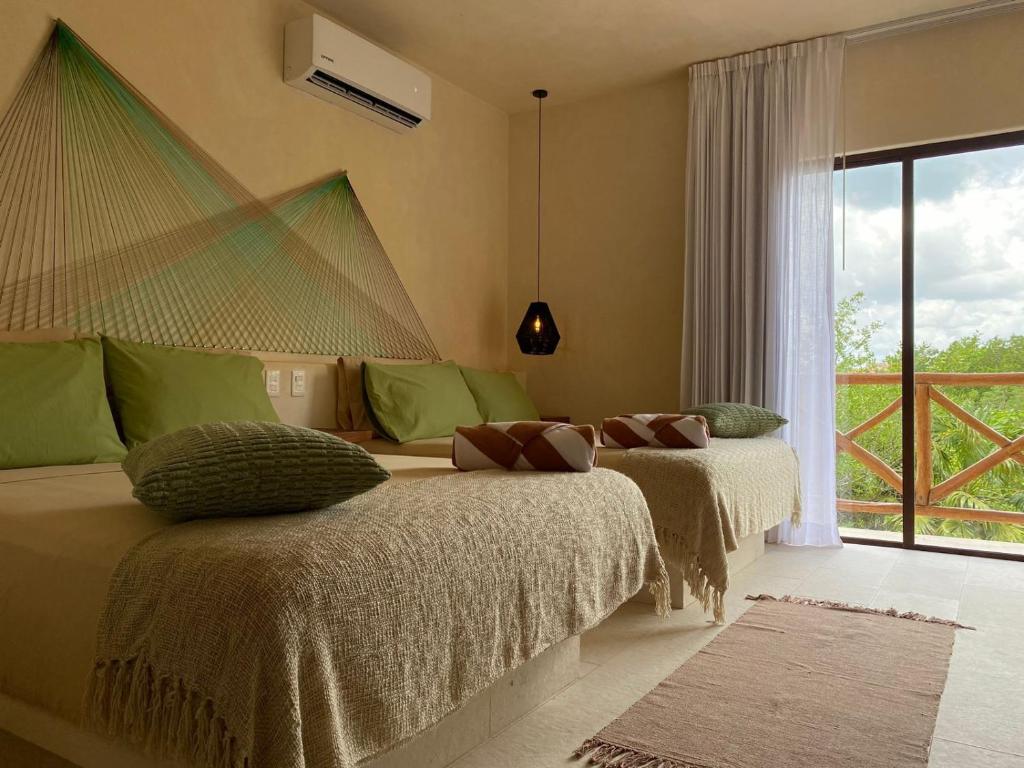 奥尔沃克斯岛Sunsteps casa holbox的带窗户的客房内的两张床