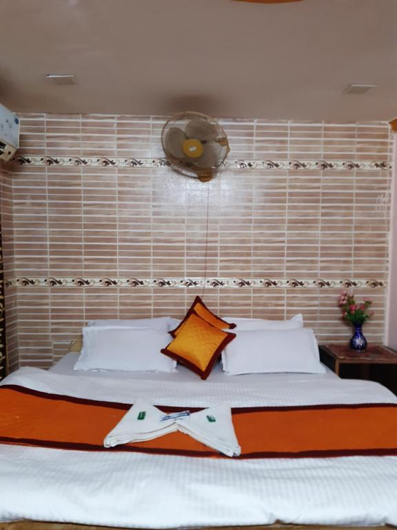 斋沙默尔Nomadic Backpackers Hostel的一间卧室配有一张大床和床头板