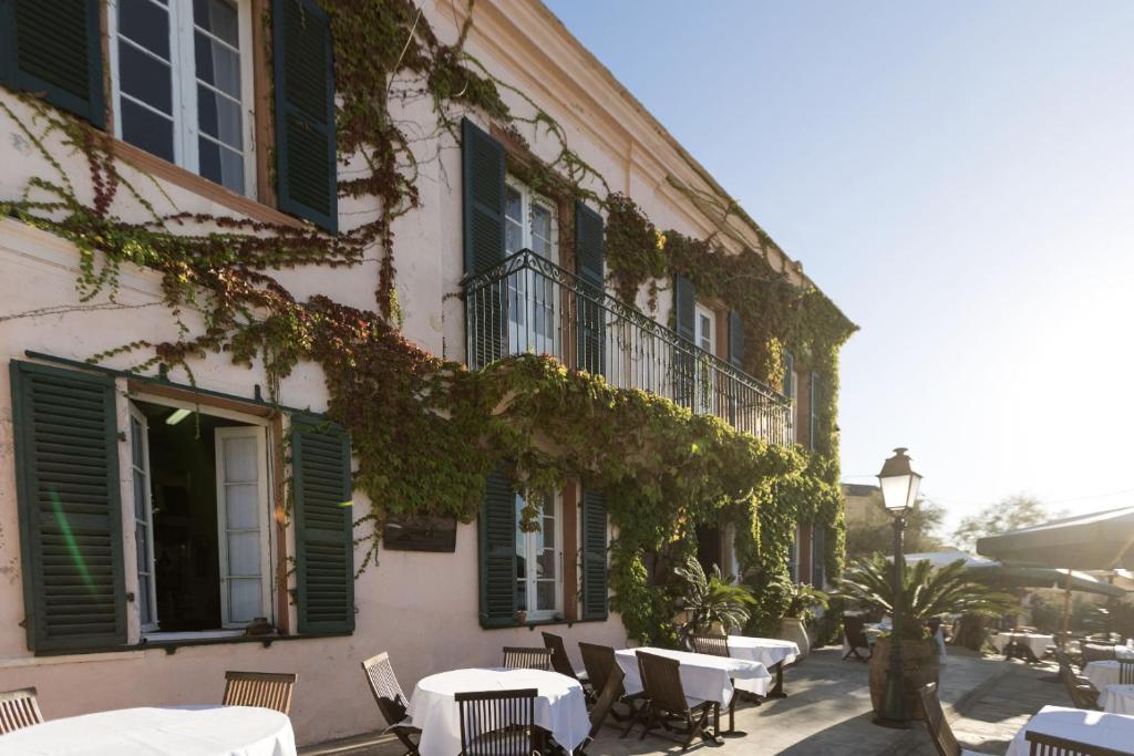 森图里Hotel-Restaurant Le Vieux Moulin的一座配有桌椅的建筑,里面常有常春藤