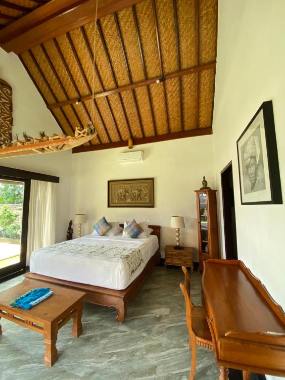 坎古普里香鱼酒店的一间卧室配有一张床、一张桌子和一张长凳