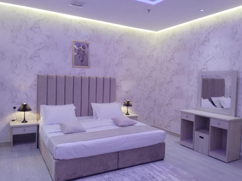 哈费尔巴廷العلي للشقق المخدومة Alalihotel的白色卧室配有床和镜子