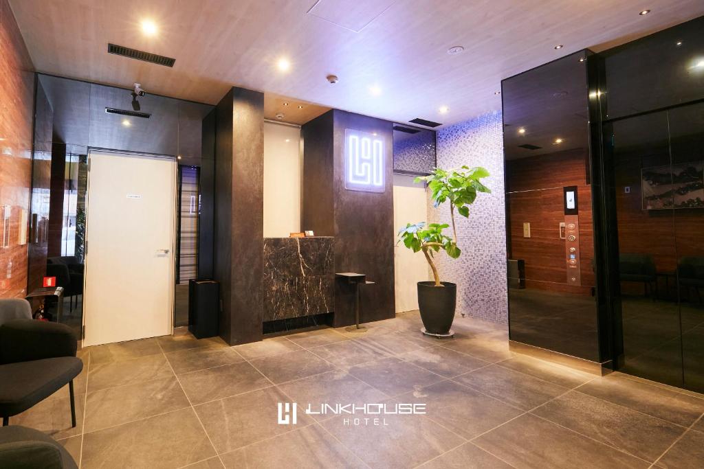 福冈LINK HOUSE HOTEL - スマート無人ステイ - Unmanned design hotel的大厅,在大楼里放着盆栽植物