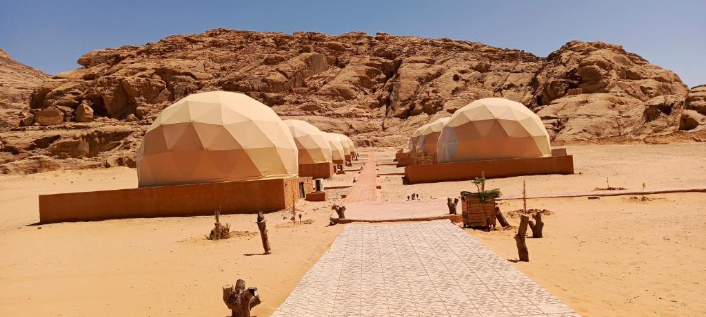 亚喀巴Wadi Rum Marcanã camp的沙漠中一排有山的圆顶