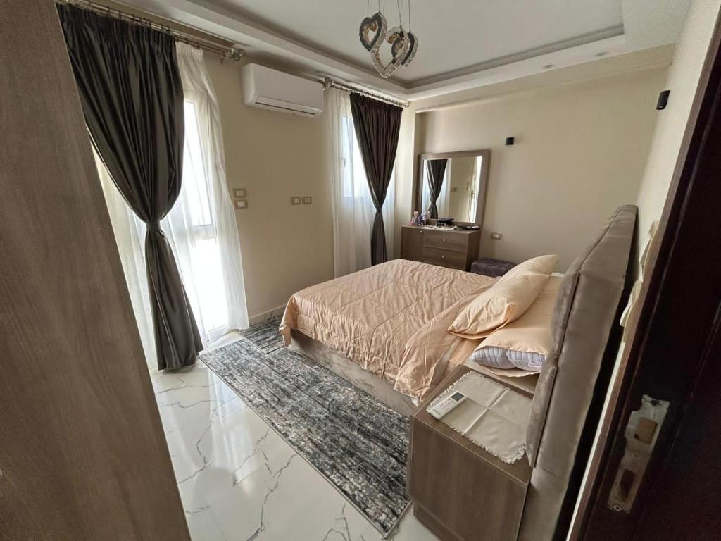 赫尔格达Apartment Hossam 1的一间卧室配有一张床和镜子