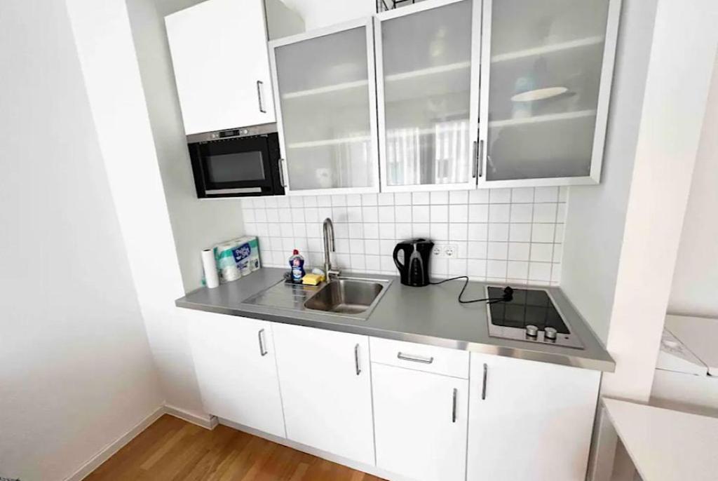 科隆Kölner Apartment direkt am Zentrum的厨房配有白色橱柜和水槽