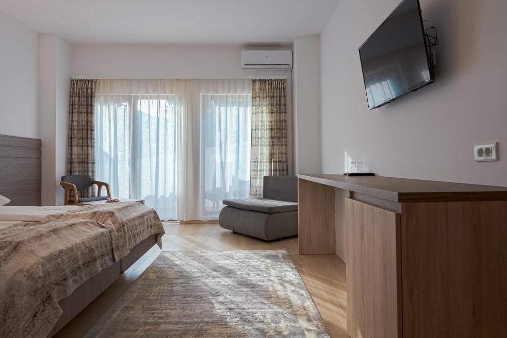 百乐·奥拉内斯蒂Hotel Cascada BAILE OLANESTI的一间卧室配有一张床和一台平面电视