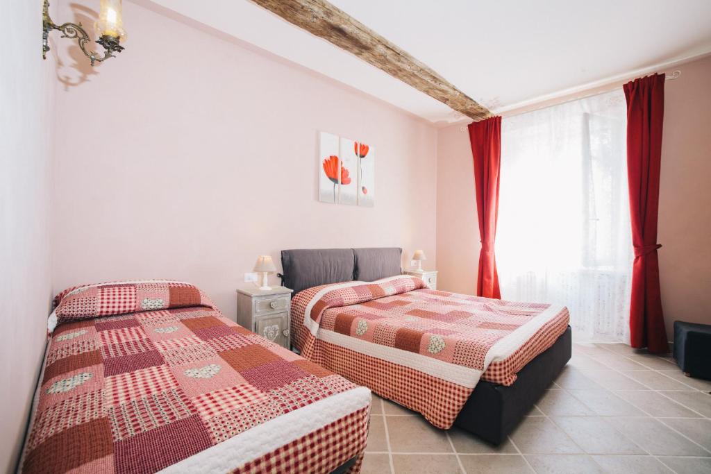 维纳利亚瑞勒狄默尔戴安娜公寓的配有红色窗帘的客房内的两张床