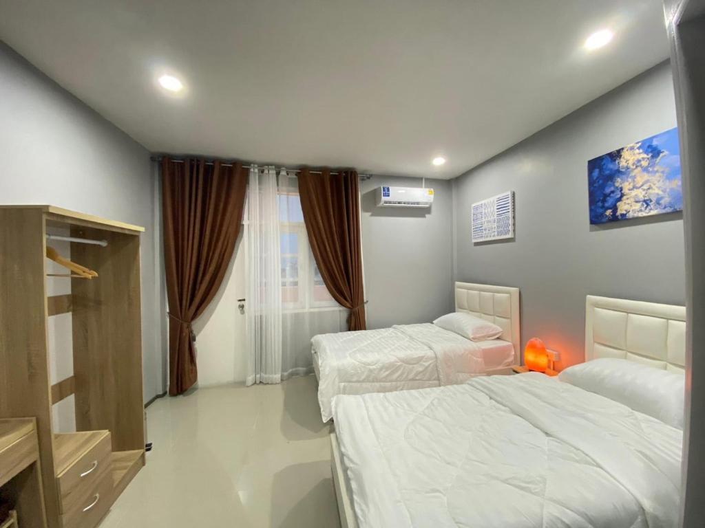 坤敬คาเฟ่ เดอ แจ่วบอง รูมแอนด์เซอร์วิส的一间卧室设有两张床和窗户。
