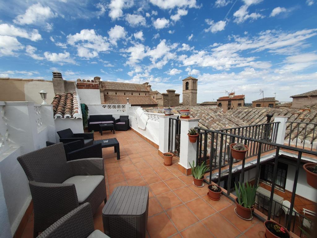 托莱多ToledoRooms Estrella - M, L, XL, XXL - Pisos con Azotea - Sun Terrace的屋顶上带桌椅的阳台