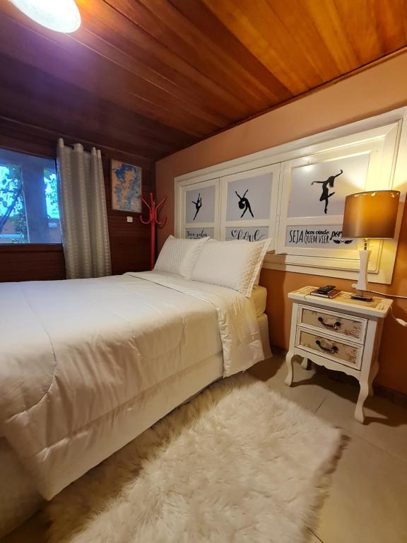 弗洛里亚诺波利斯Casa da Rosa hospedagem em Florianópolis的一间卧室配有一张床和一张带台灯的桌子