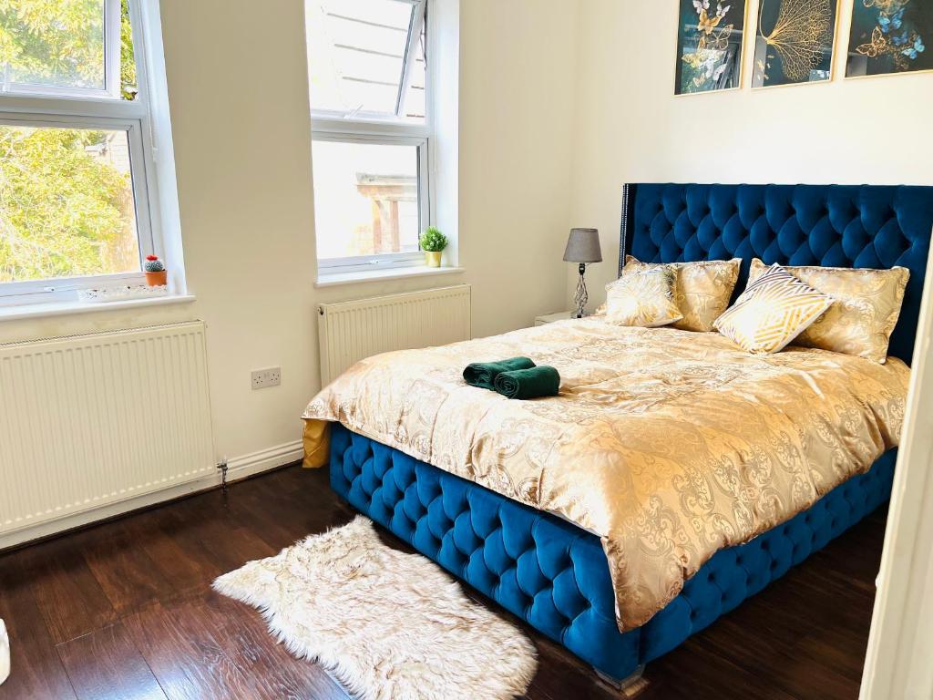 伦敦Luxury Morden 4 bedroom Flats which will make you unforgettable的卧室设有一张蓝色的床,设有两个窗户