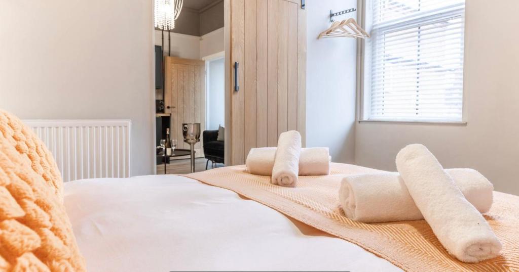 埃尔斯米尔Modern boutique apartment for 4- central Ellesmere的卧室配有白色床和毛巾