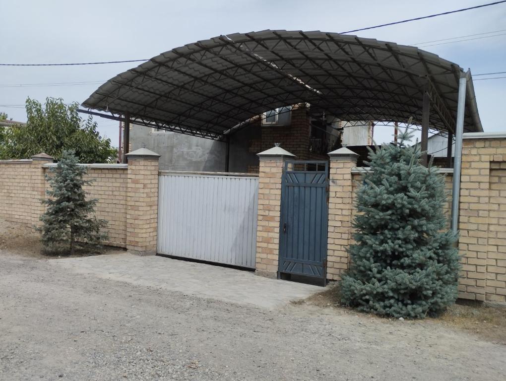 比什凯克Гостевой дом Энесай的房屋设有车库、门和围栏