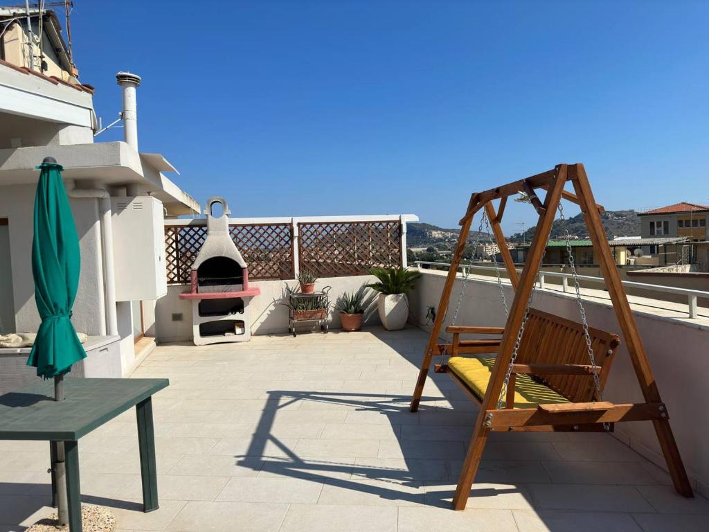 卡利亚里Nuovo attico con terrazza 5 minuti dal mare的一个带吊床的屋顶庭院