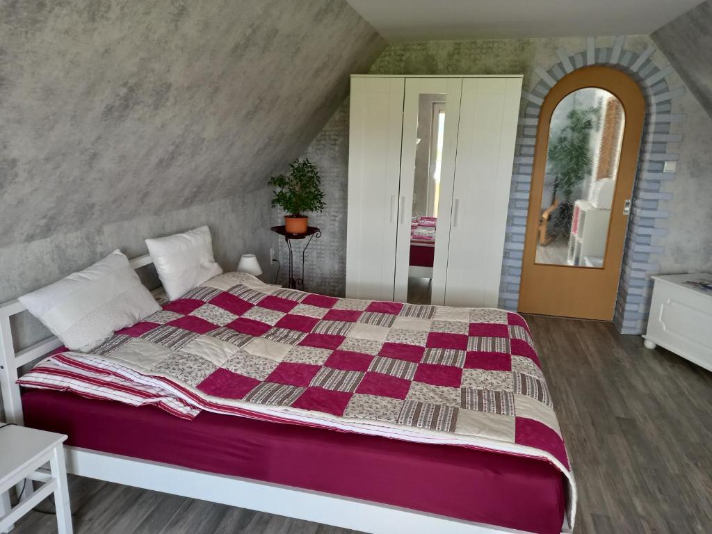 KonradsreuthFerienwohnung, Urlaub im Frankenwald的一间卧室配有一张大床和紫色棉被
