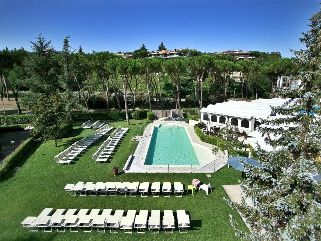 罗马全时瑞雷斯及运动酒店的享有带躺椅的游泳池和度假村的空中景致